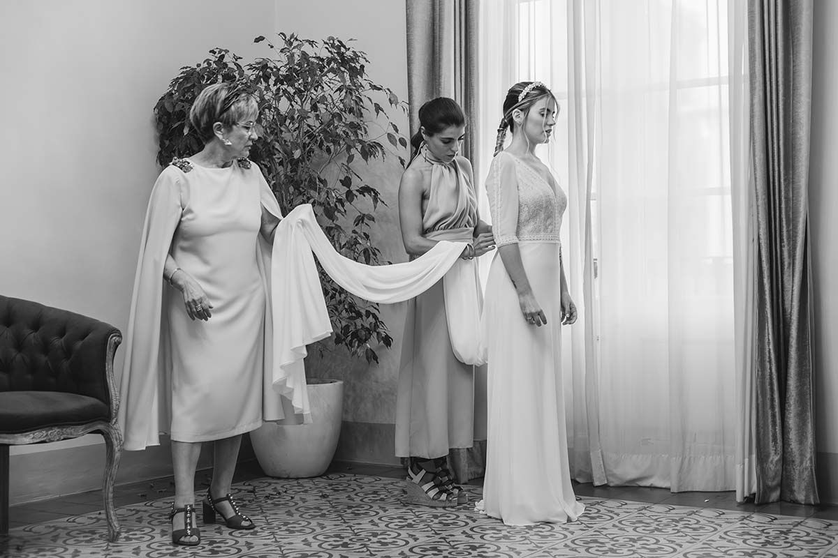 Una fotografía en blanco y negro de una novia y sus damas de honor preparándose para una boda.