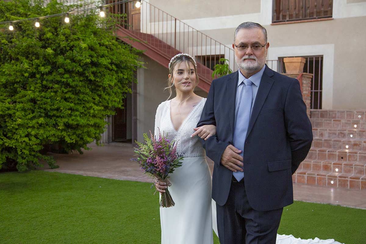 Una novia camina por el pasillo con su padre.