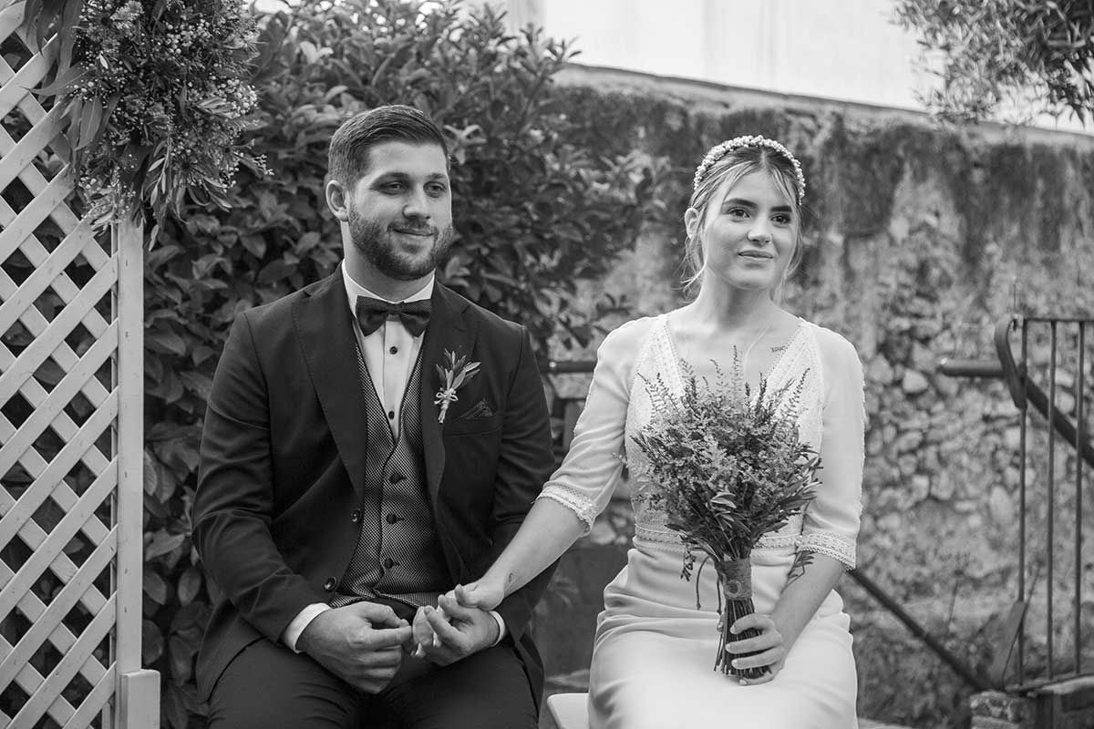 Una fotografía en blanco y negro de una novia y un novio tomados de la mano.