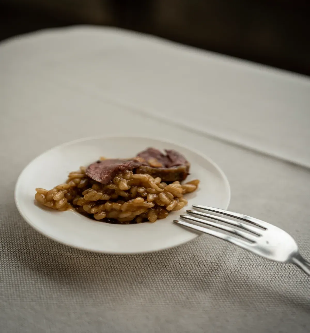 Un plato de comida con un tenedor sobre una mesa.
