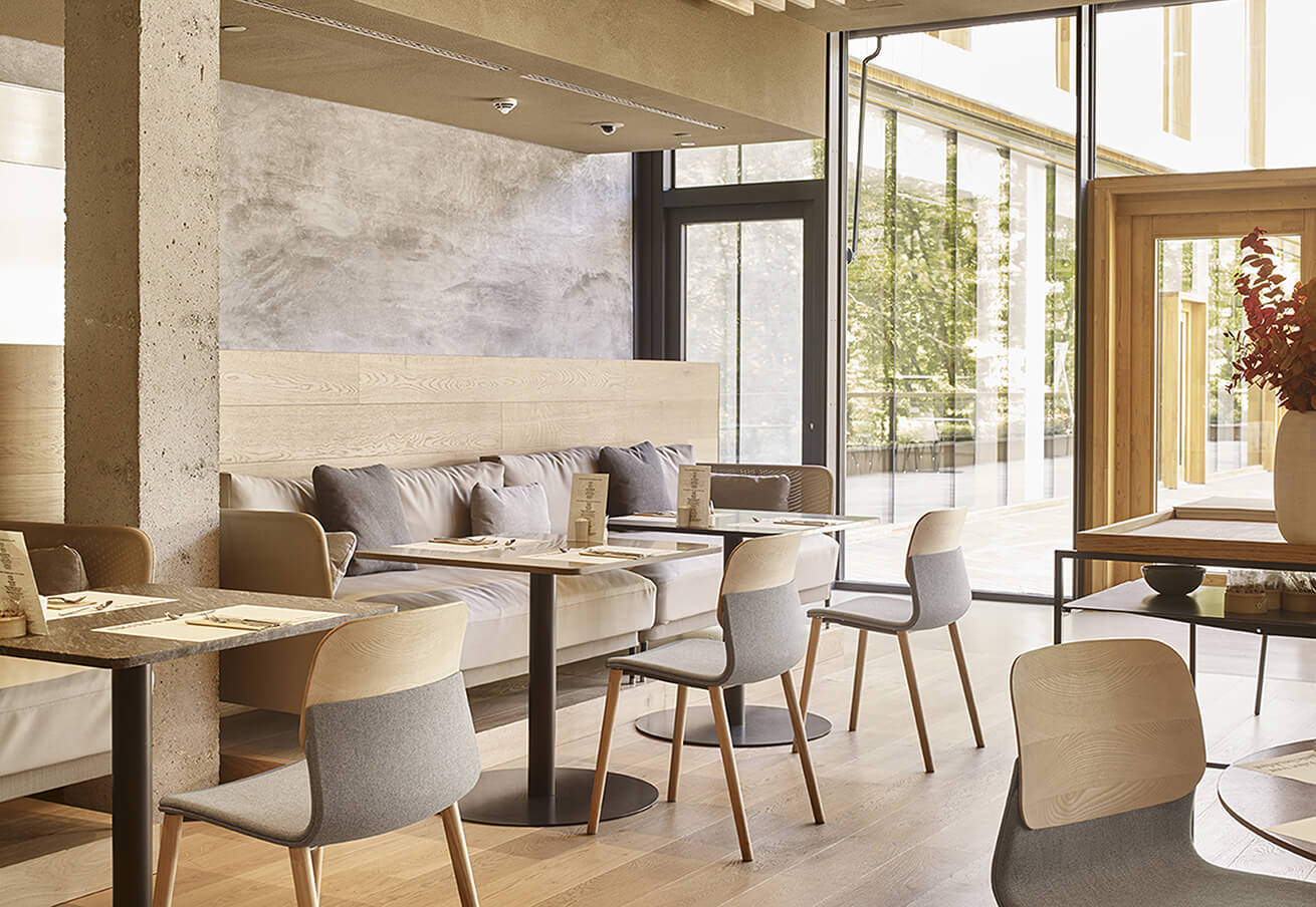 Table de repas en bois avec chaises grises et banquettes confortables