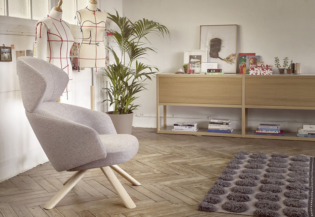 Fauteuil gris confortable avec meuble en bois et tapis gris