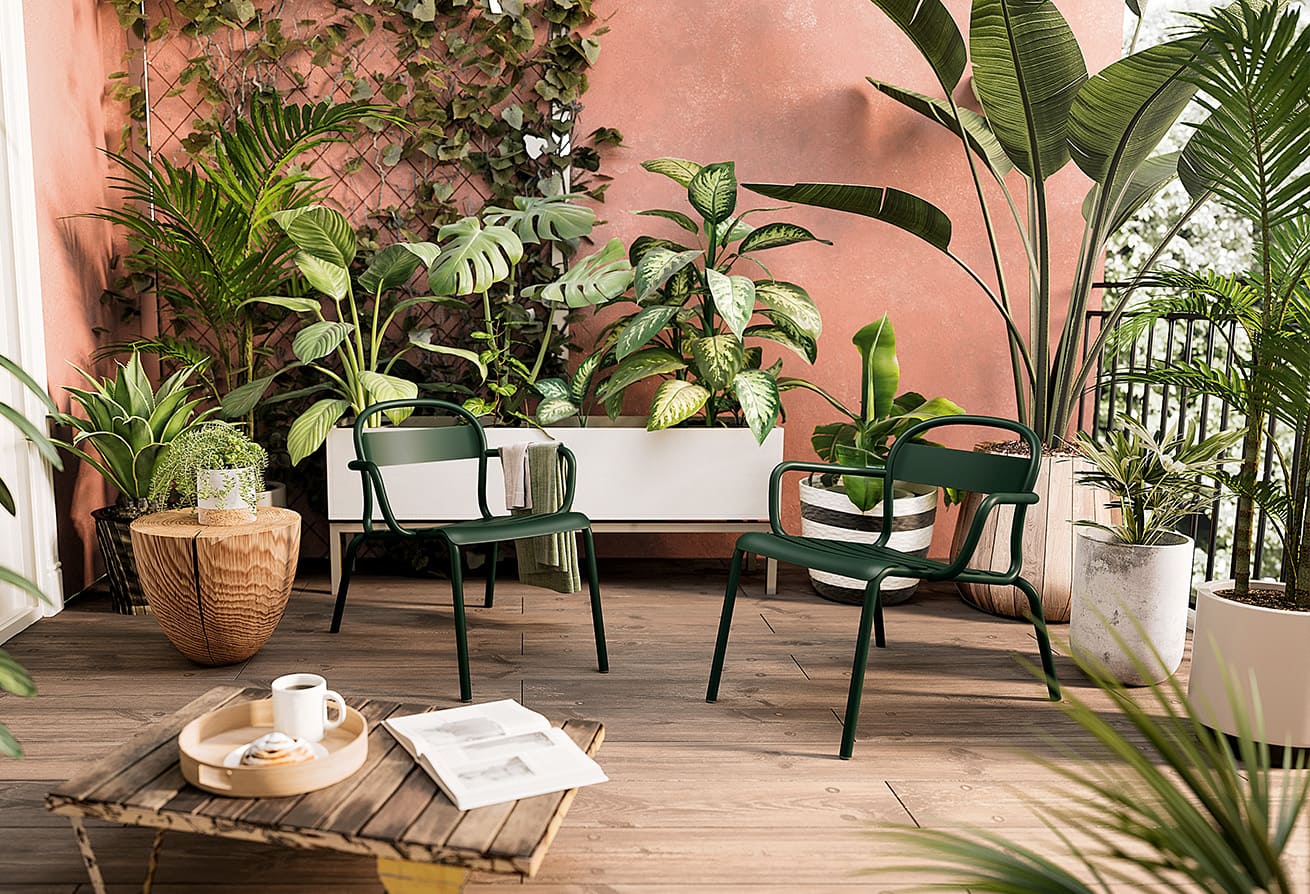 Espace détente avec de multiples plantes et deux chaises vertes