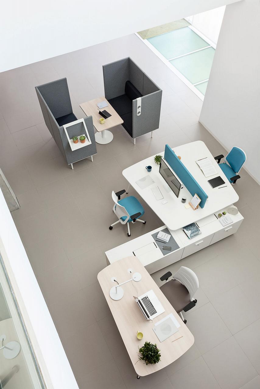 Espace bureau avec éléments bleus et espace détente avec banquettes grises