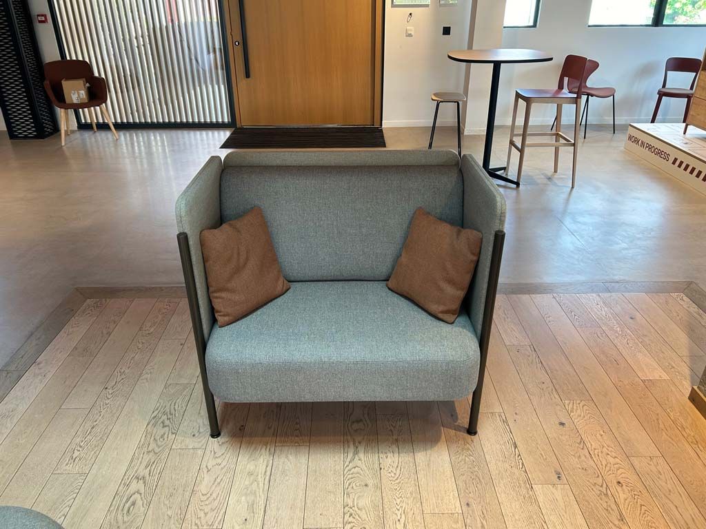 Fauteuil en tissu gris avec coussins marrons