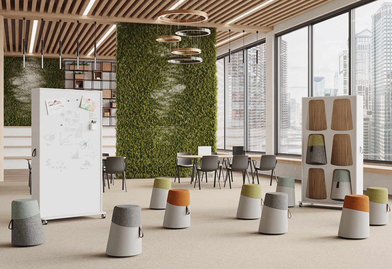 Grande salle de réunion aménagée avec un tableau et des poufs