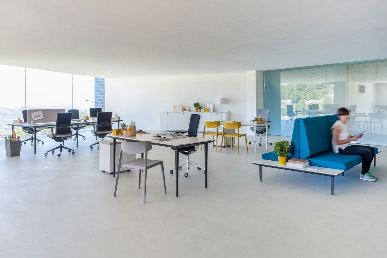 Open space avec petits bureaux et banquette bleue