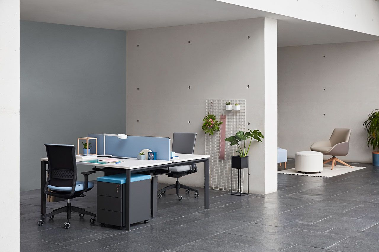 Bureaux avec séparateur et fauteuils qui se font face