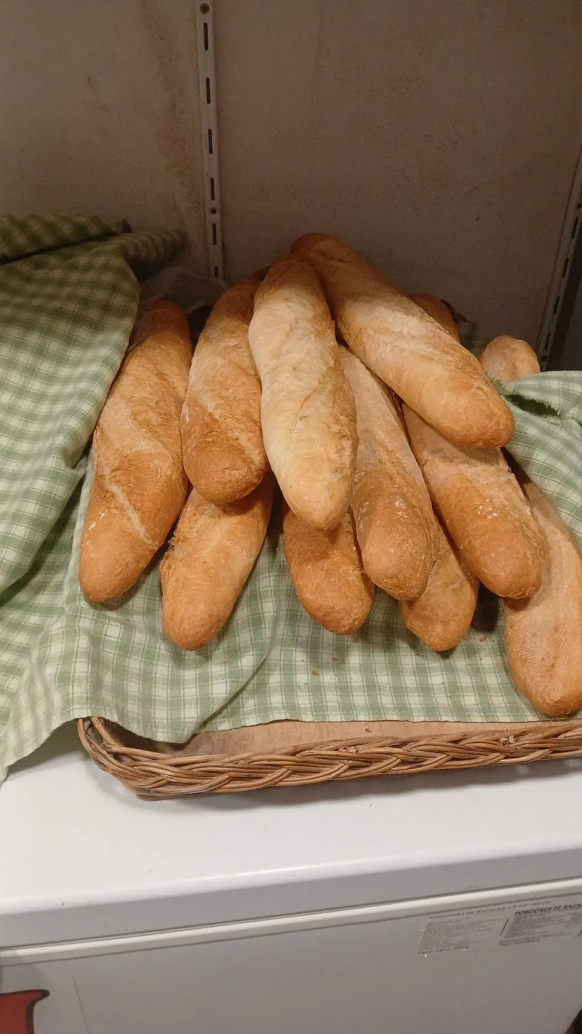 Bagels en una cesta tejida, sobre un paño a cuadros verde.