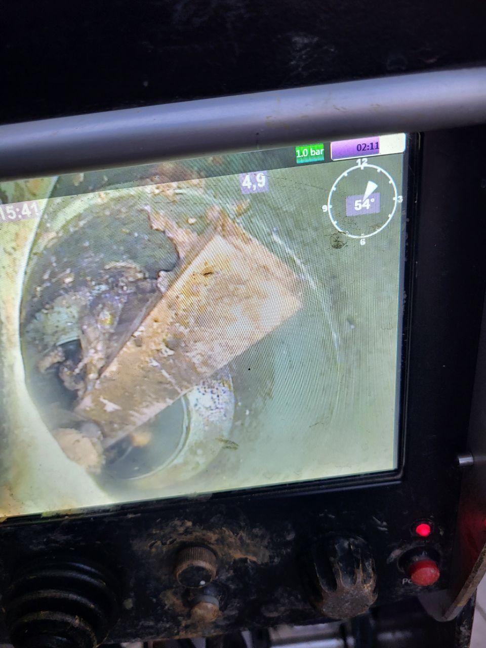 Regenwasser tropft während eines Sturms von einem grauen Dach in eine Dachrinne und ein Fallrohr.