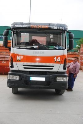 Un hombre está parado junto a un camión con el número 14.