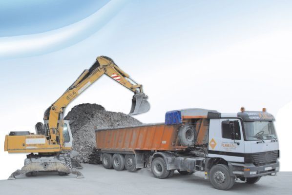 Una excavadora está cargando un camión volquete con tierra.