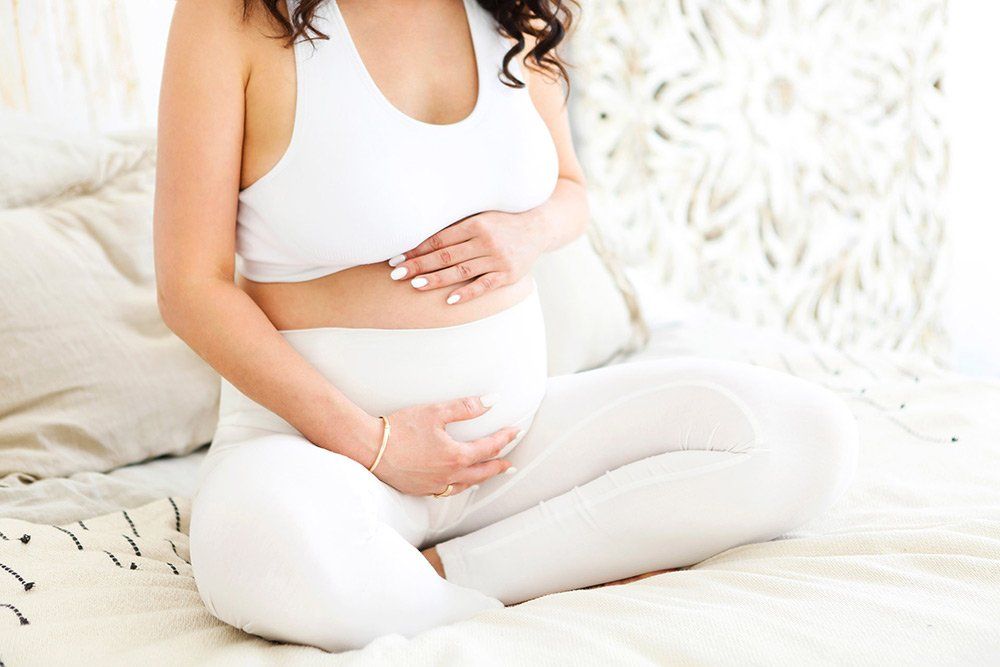 Schwangere Frau zeigt Bild von der Echografie