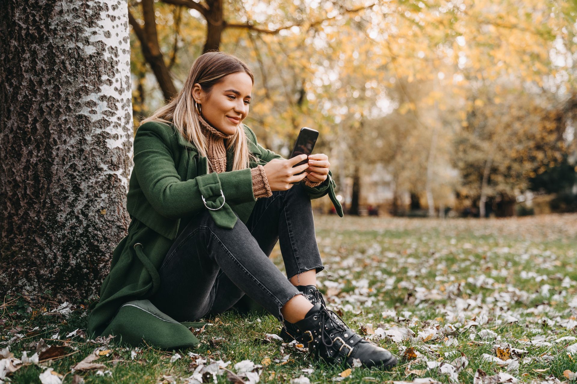 Femme dans un parc avec son smartphone à la main