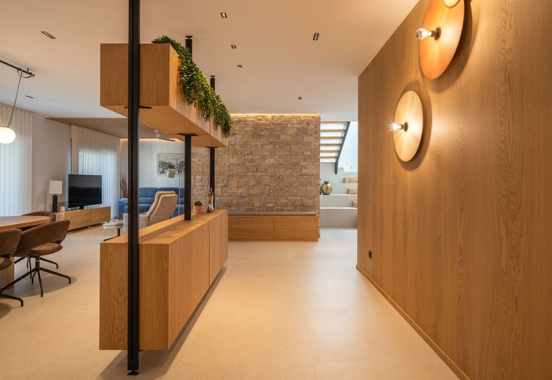 Interior moderno con una pared revestida de madera, apliques de pared redondos, una pared decorativa de piedra