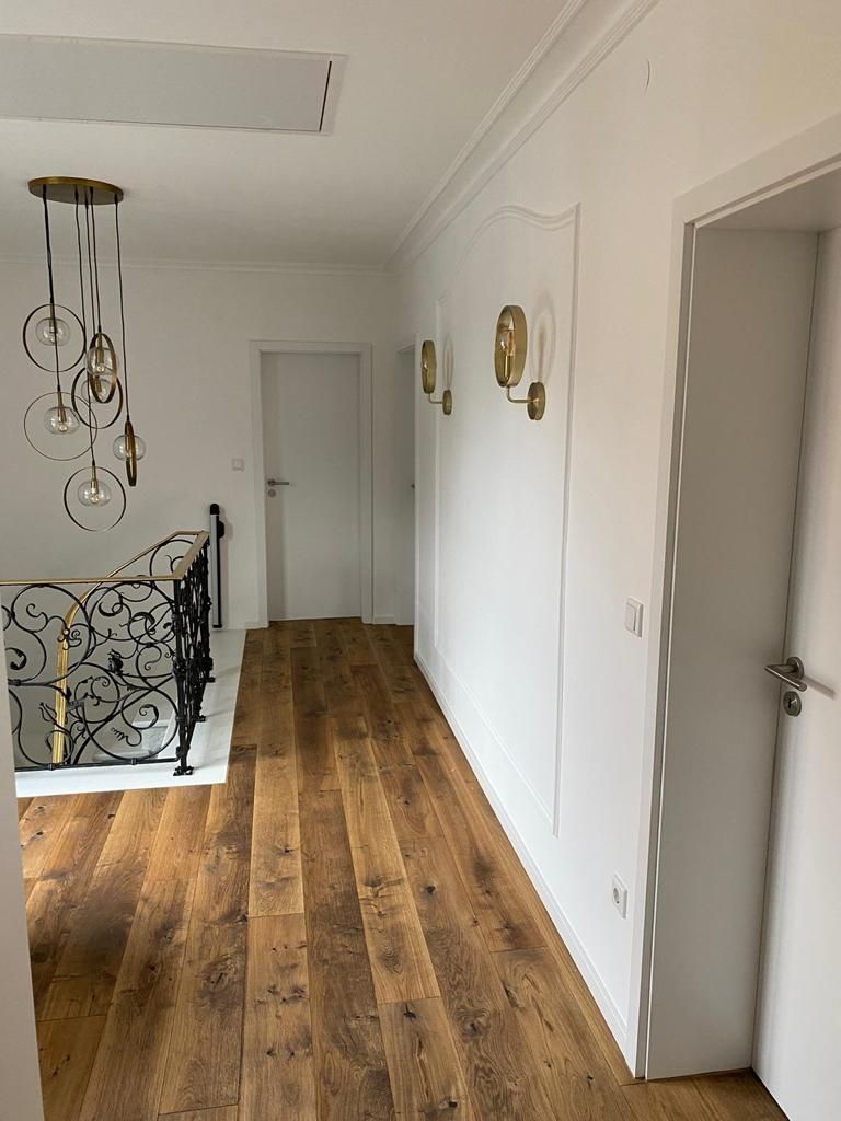 Renovierter Hausflur mit weiß gestrichenen Wänden – Malerarbeiten von der Malerei Segerer.