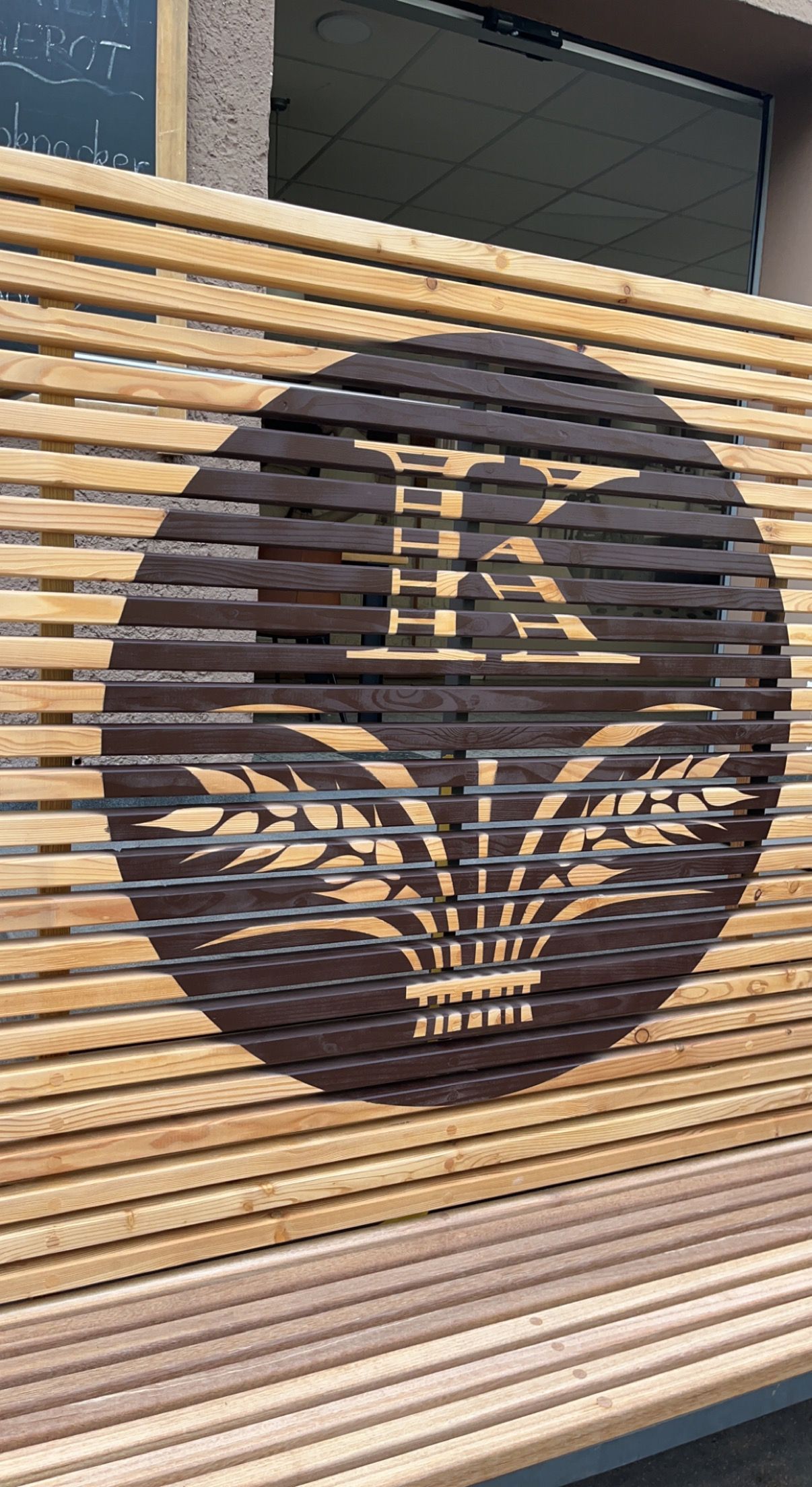 Holzverkleidung mit stilisiertem Logo – handgefertigtes Design von der Malerei Segerer.