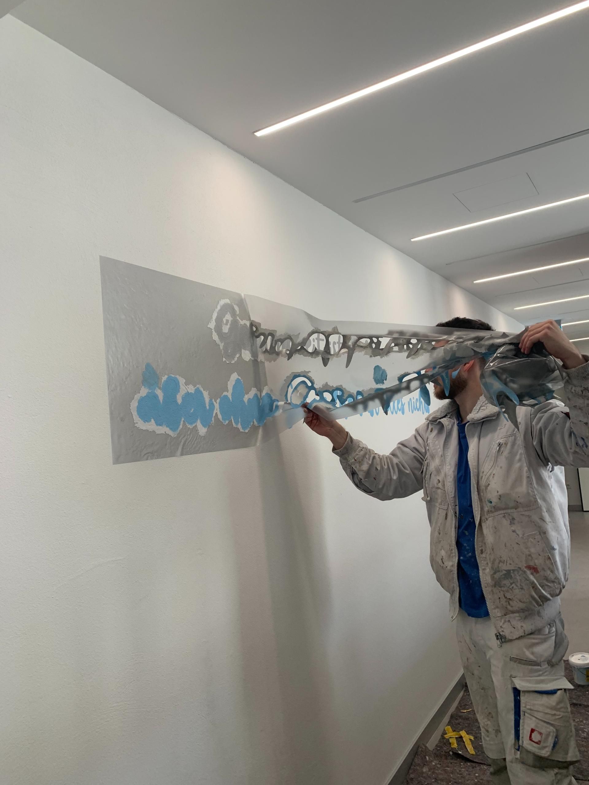 Maler trägt Wandkunst mit Spachteltechnik auf – kreative Arbeit der Malerei Segerer.