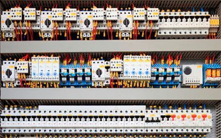 Un primer plano de un panel de control eléctrico lleno de muchos equipos eléctricos.