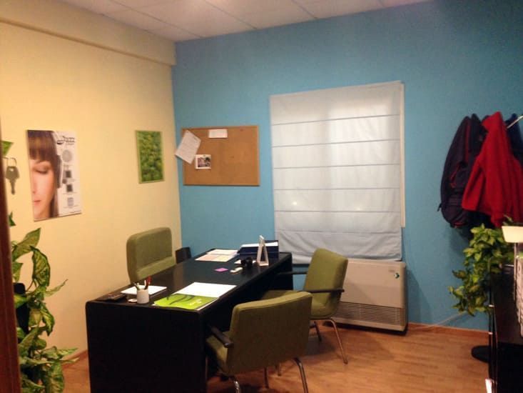 Una habitación con paredes azules y un escritorio y sillas.