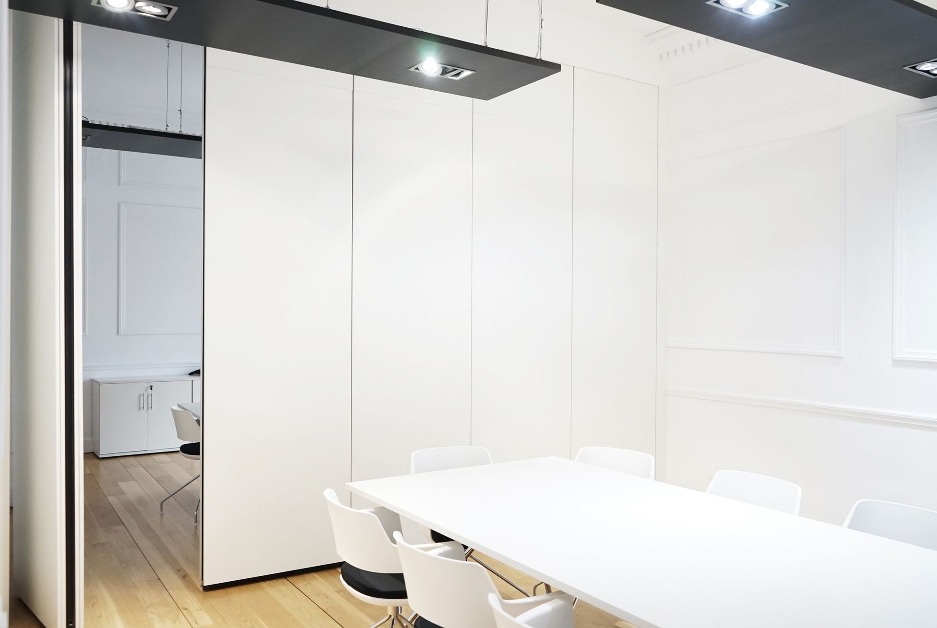 Una sala de conferencias con una larga mesa blanca y sillas.