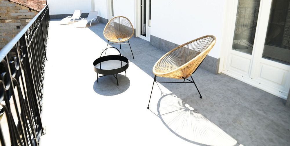 Un balcón con dos sillas y una mesa.