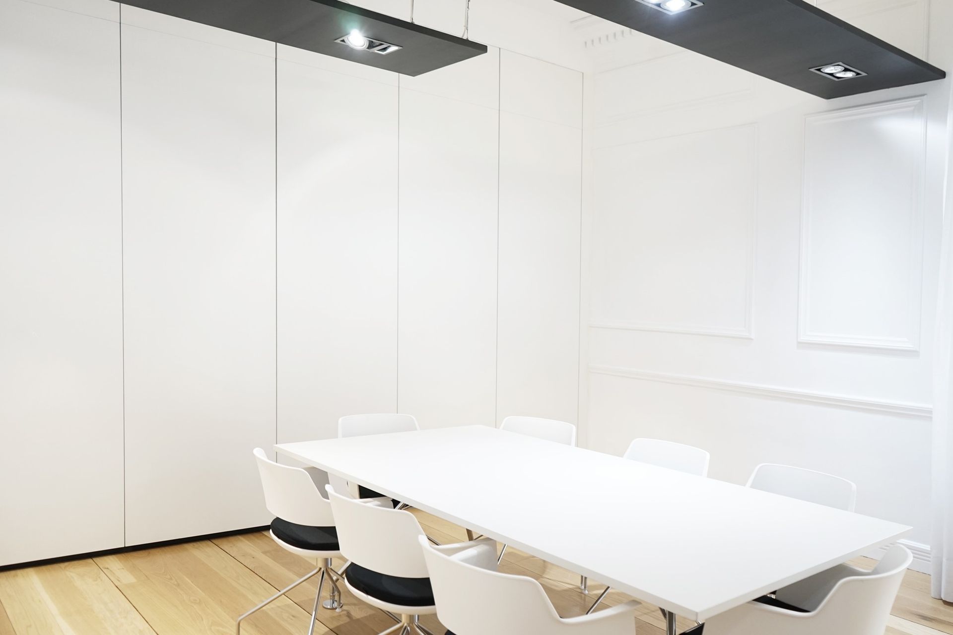 Una sala de conferencias con una larga mesa blanca y sillas.