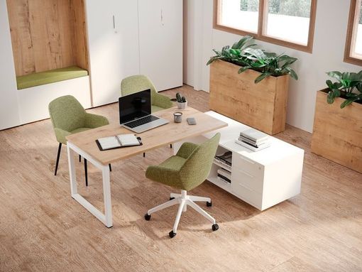 Hay un escritorio con una computadora portátil en el medio de la habitación.