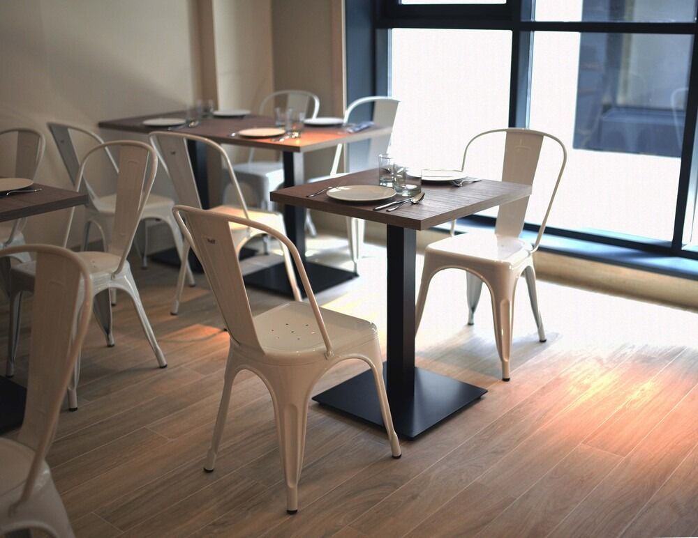 Un restaurante con mesas y sillas frente a una ventana.