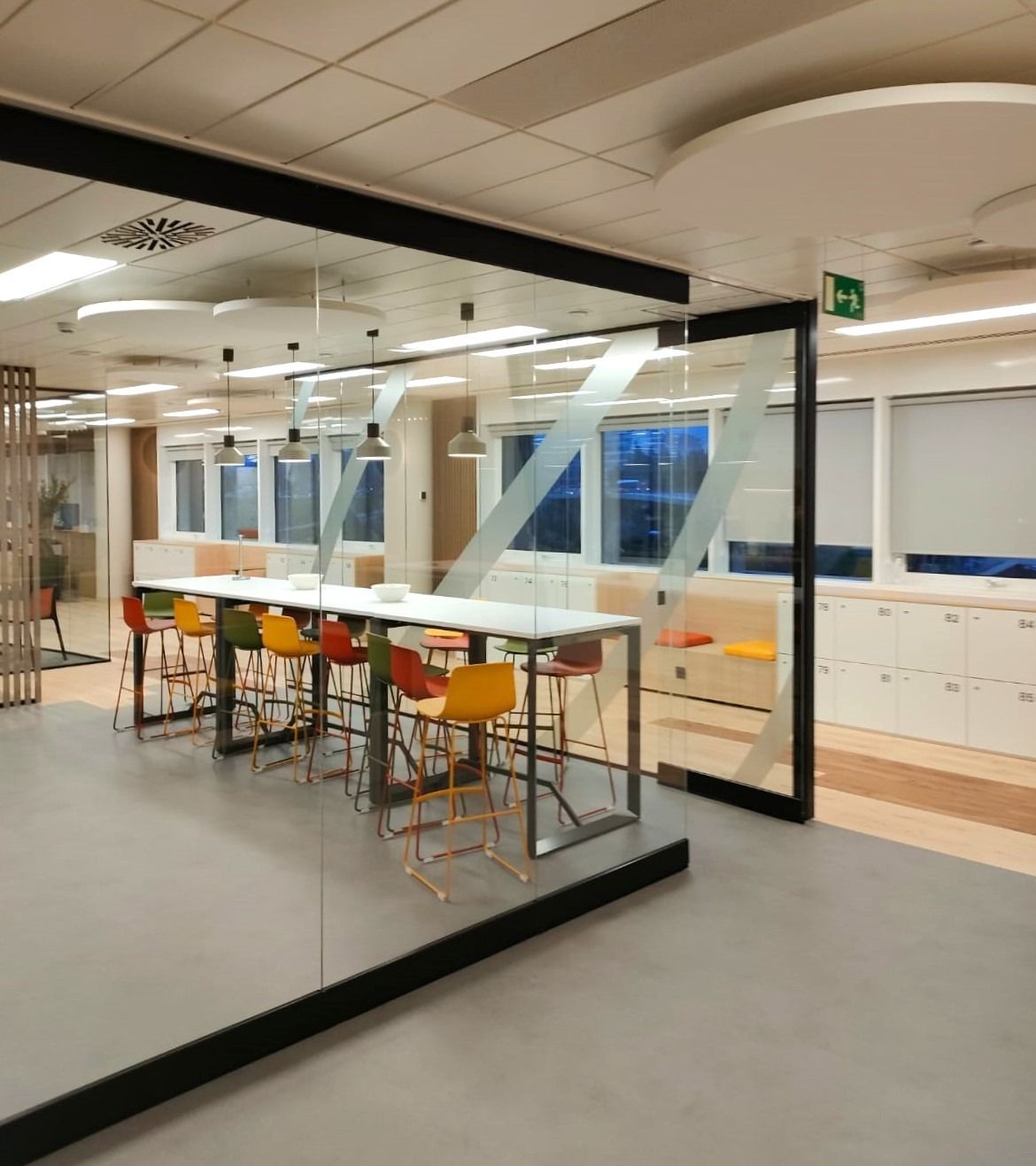 Una habitación grande con una pared de cristal y mesas y sillas.