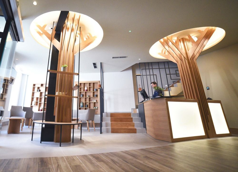 Un hombre está sentado en un escritorio en el vestíbulo de un hotel.