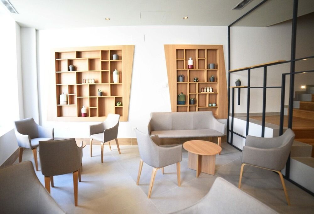 Una sala de estar con sofá, sillas, mesas y estantes.