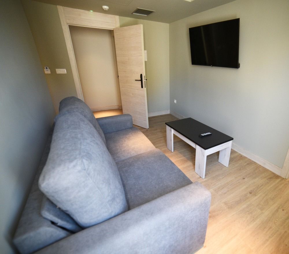 Una sala de estar con sofá, mesa de café y televisión.