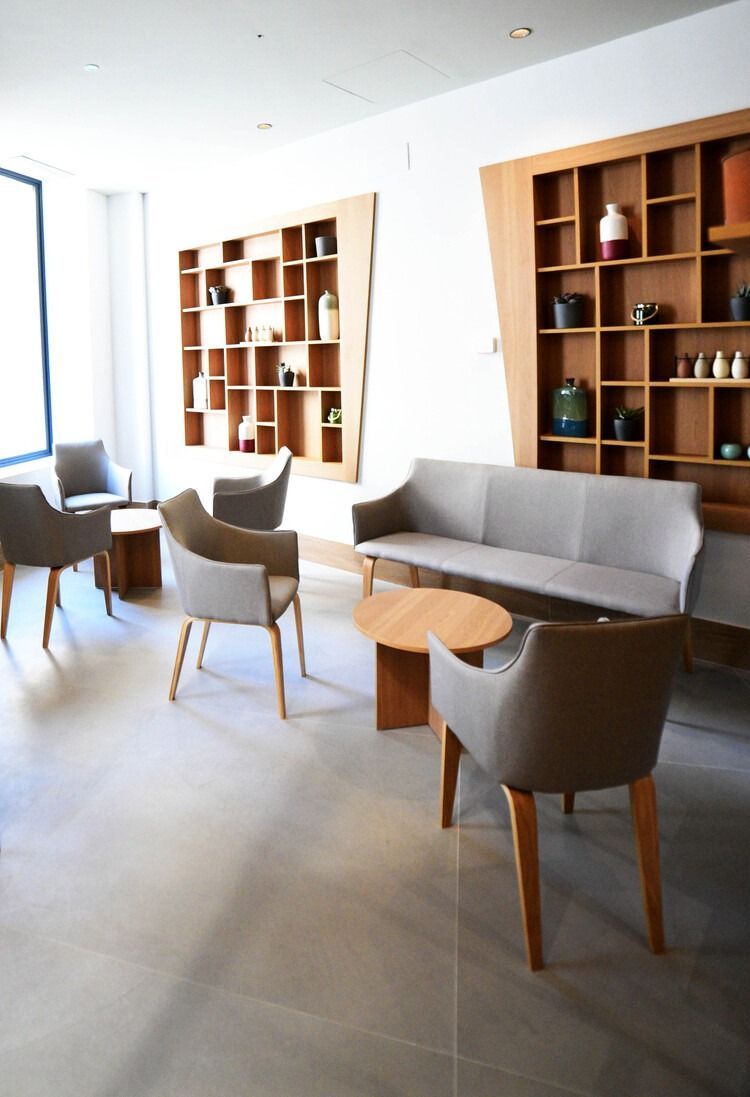Una sala de estar con un sofá, sillones y una mesa.