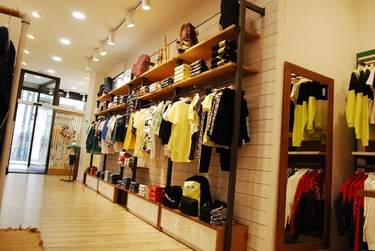 Una tienda llena de mucha ropa y un espejo.