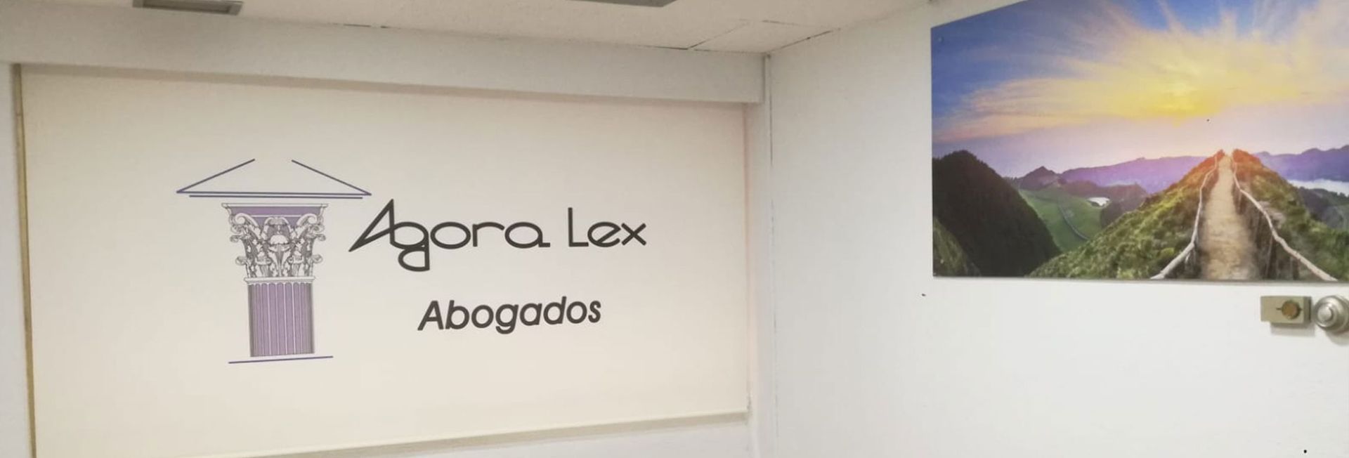 Una habitación con un cartel en la pared que dice agora lax abogados.