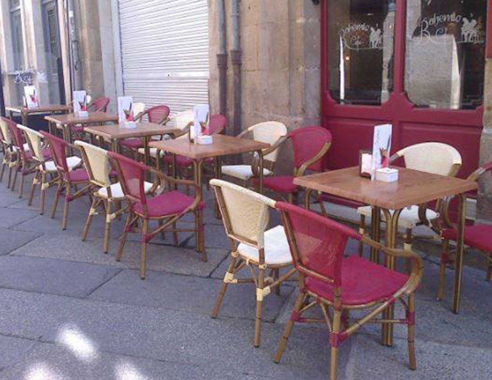 Una fila de mesas y sillas afuera de un restaurante.