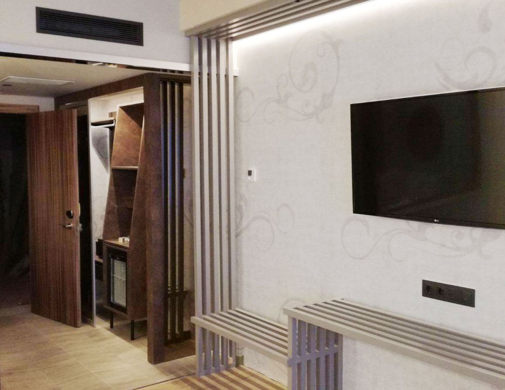 Una habitación de hotel con un televisor de pantalla plana en la pared.