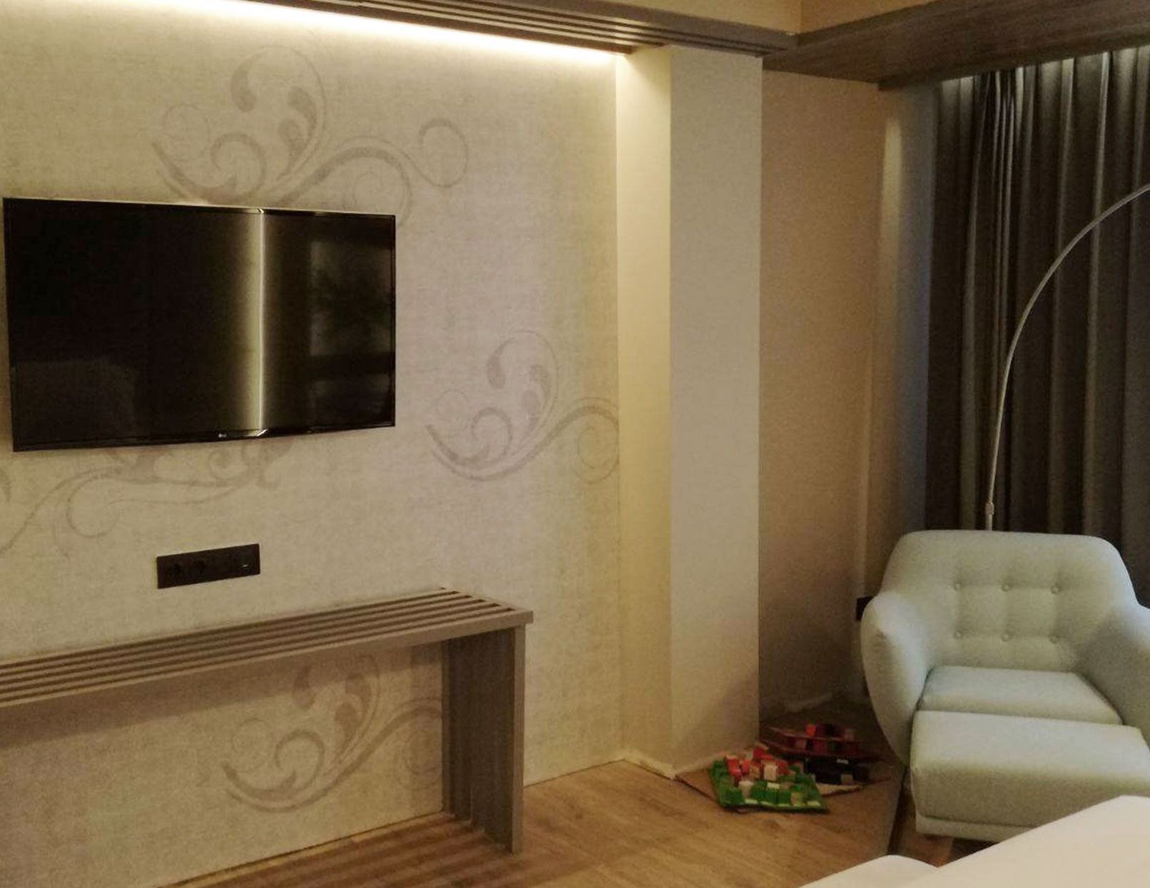 Una habitación de hotel con un gran televisor de pantalla plana en la pared.