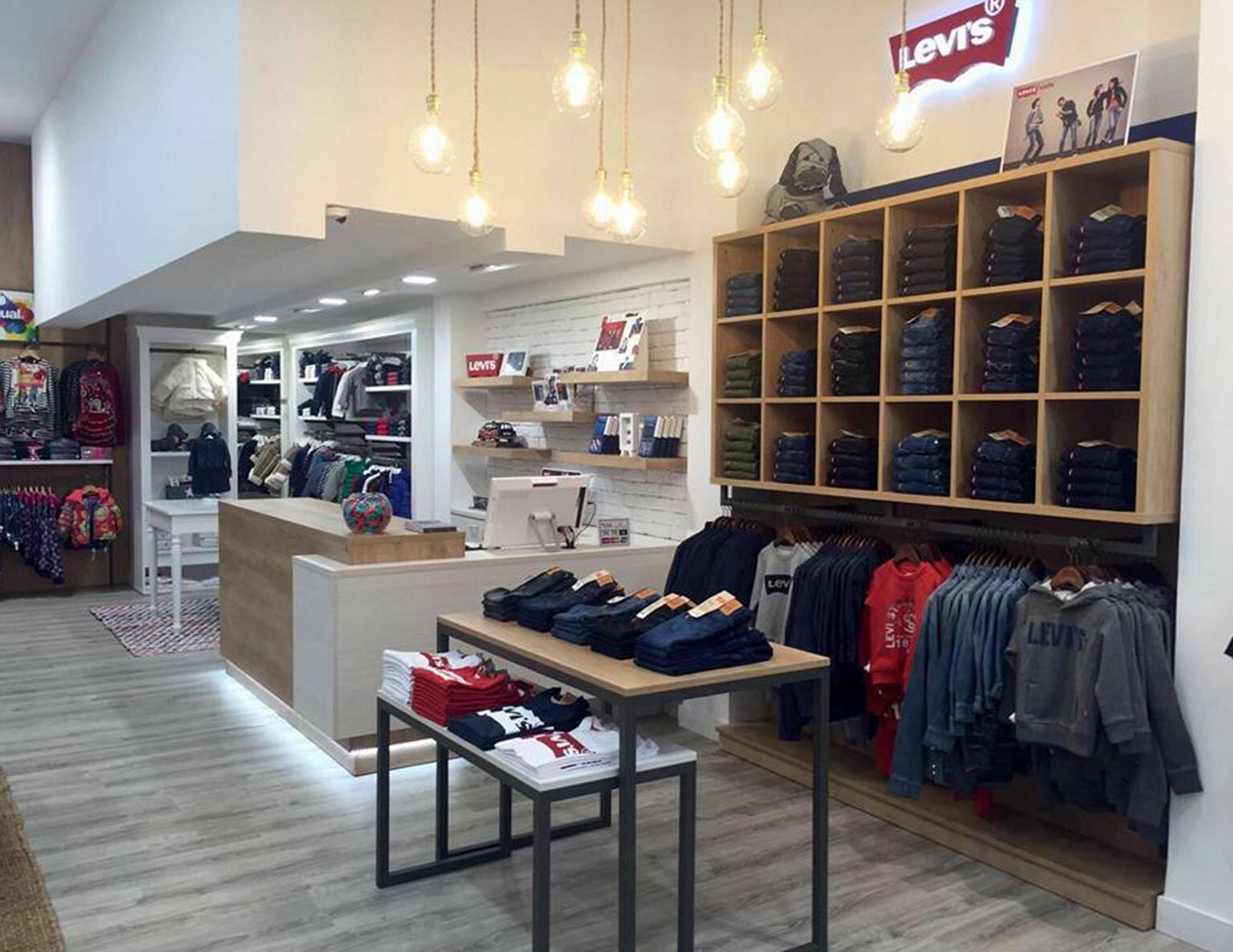 Una tienda llena de mucha ropa y mesas.