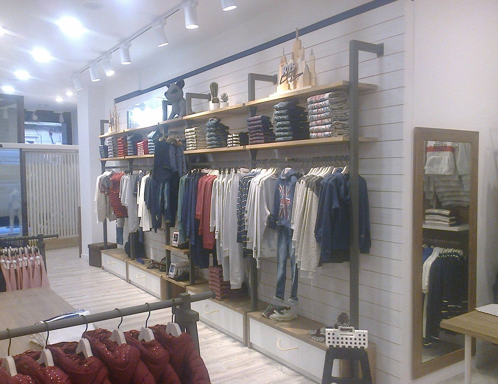 Una tienda de ropa con ropa colgada en percheros y estantes.