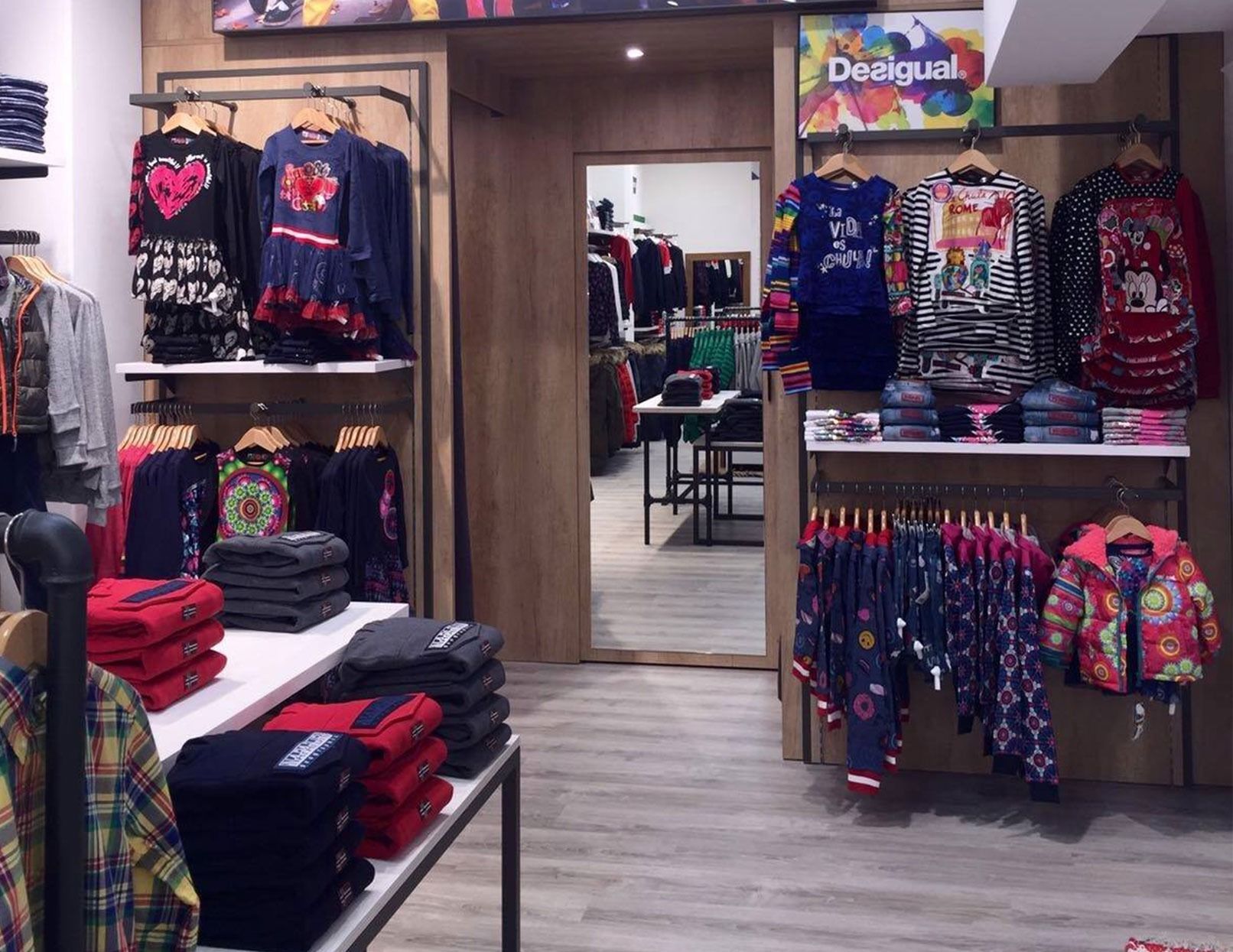 Una tienda llena de ropa y un cartel que dice desigual