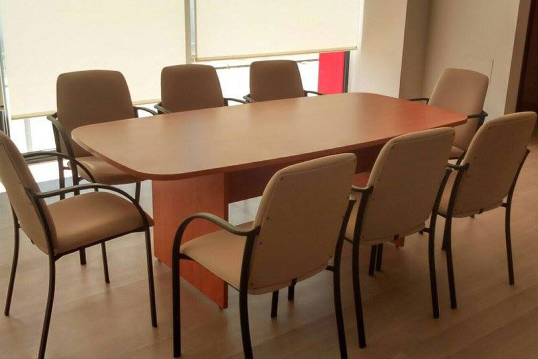 Una sala de conferencias con una mesa larga y sillas