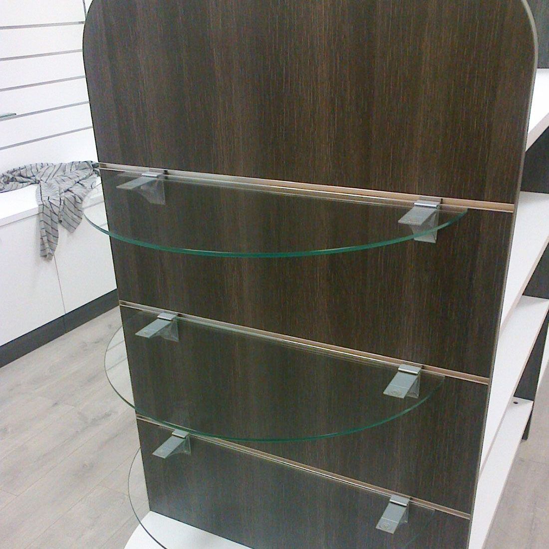 Un estante de madera con estantes de vidrio adjuntos.