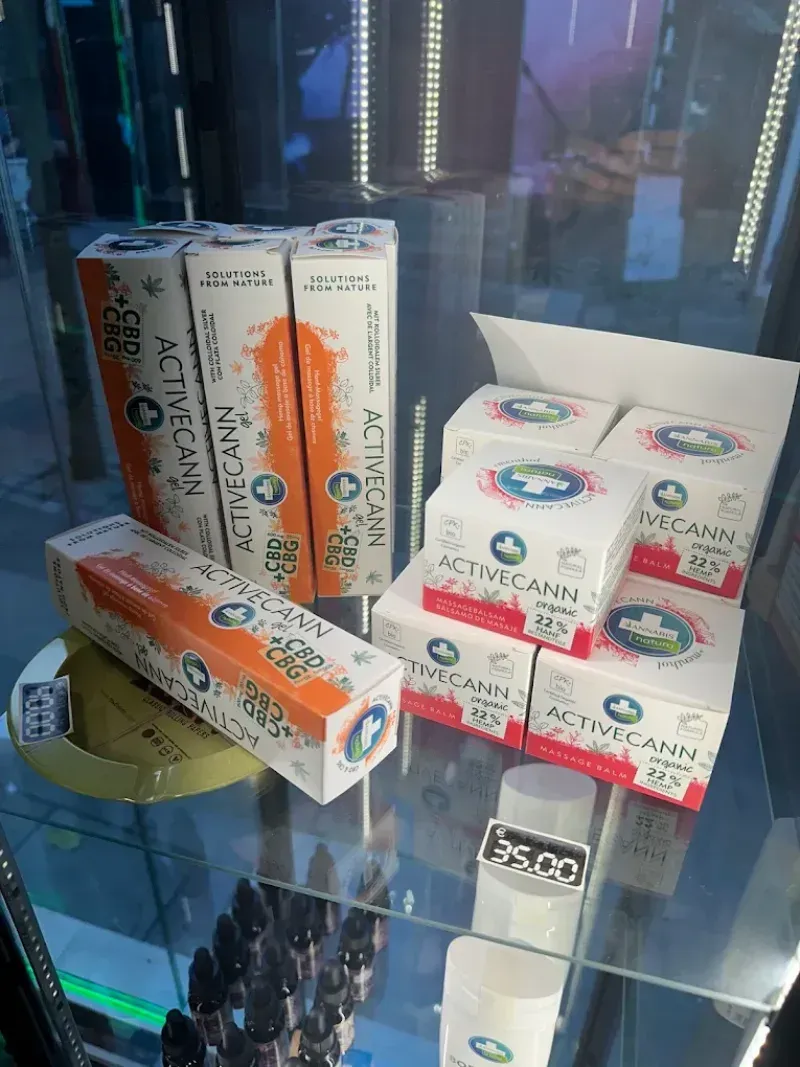 Cajas de productos de CBD en una vitrina. Envase naranja y blanco con logotipo azul.