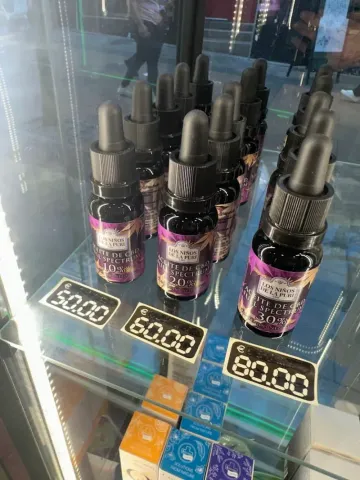 Botellas con goteros y etiquetas con precios que van desde $50 a $80 dentro de una vitrina.