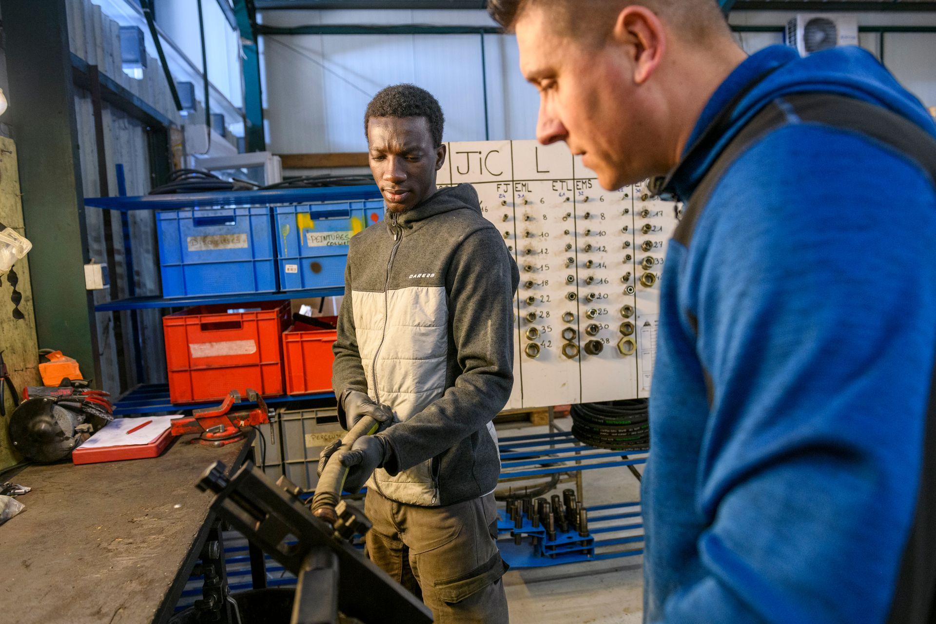 Deux employés réparant un flexible
