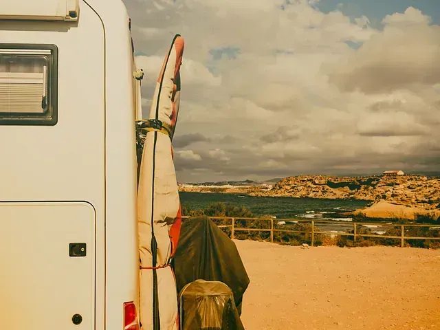 Una tabla de surf está colgada en la parte trasera de una autocaravana.