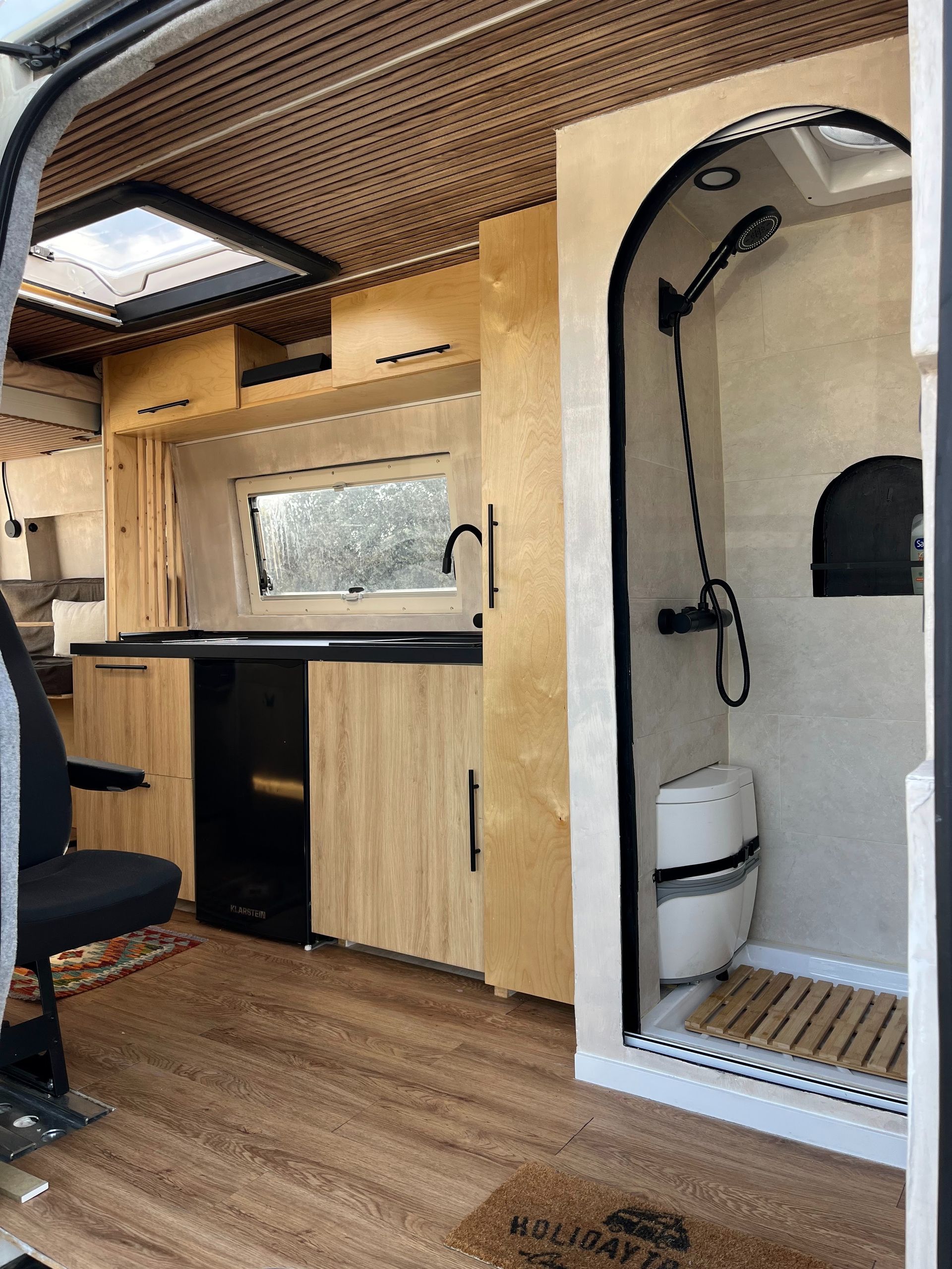 El interior de una furgoneta camper con baño y ducha.