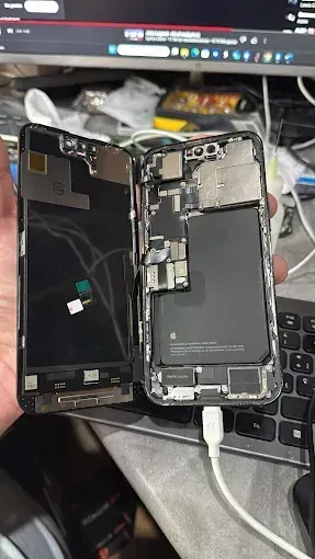 Una persona sostiene un teléfono celular que ha sido desmontado.
